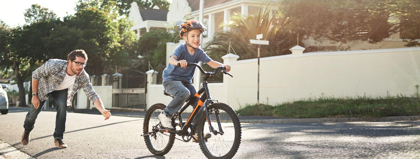 Child on bike with father